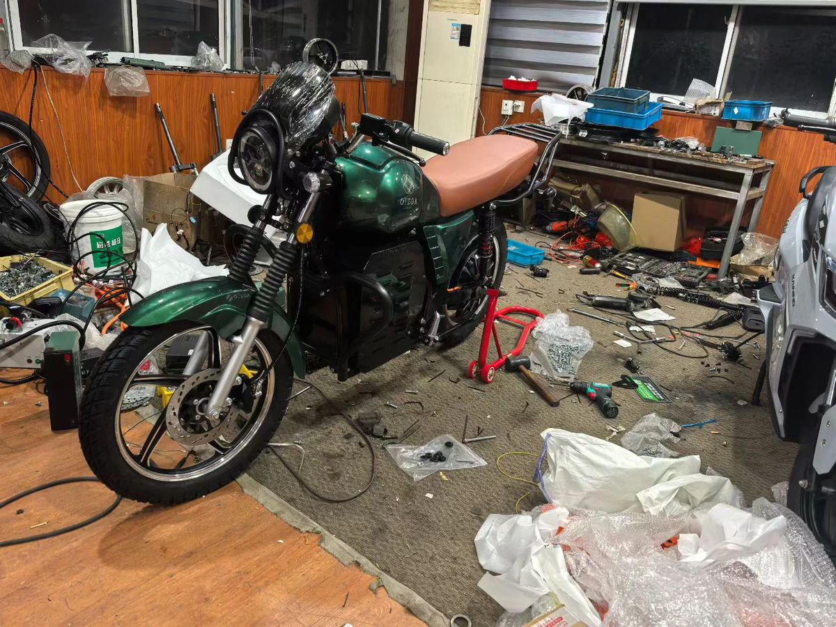 Dark-green retro-cruiser e-motorcycle prototype on the OEM pilot line
