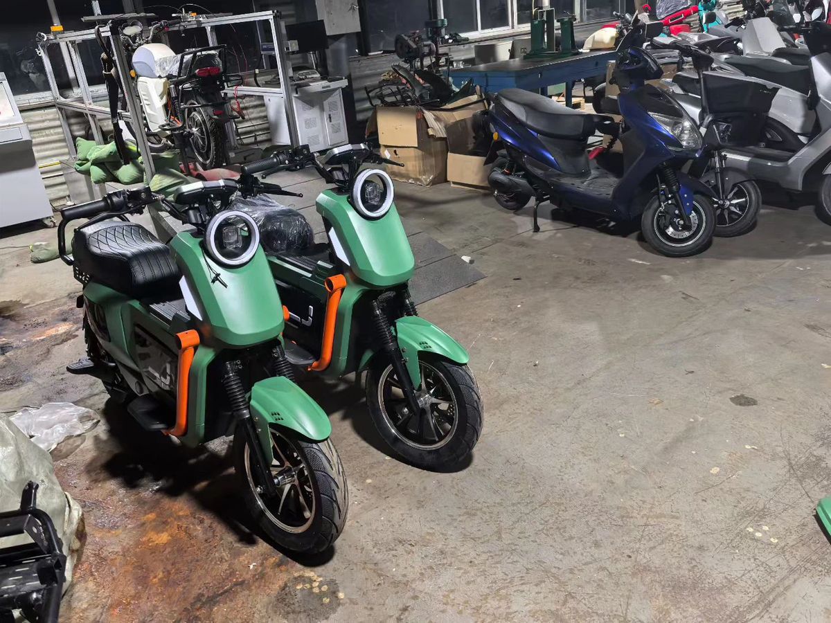 Two matte army-green sporty e-scooter prototypes side by side